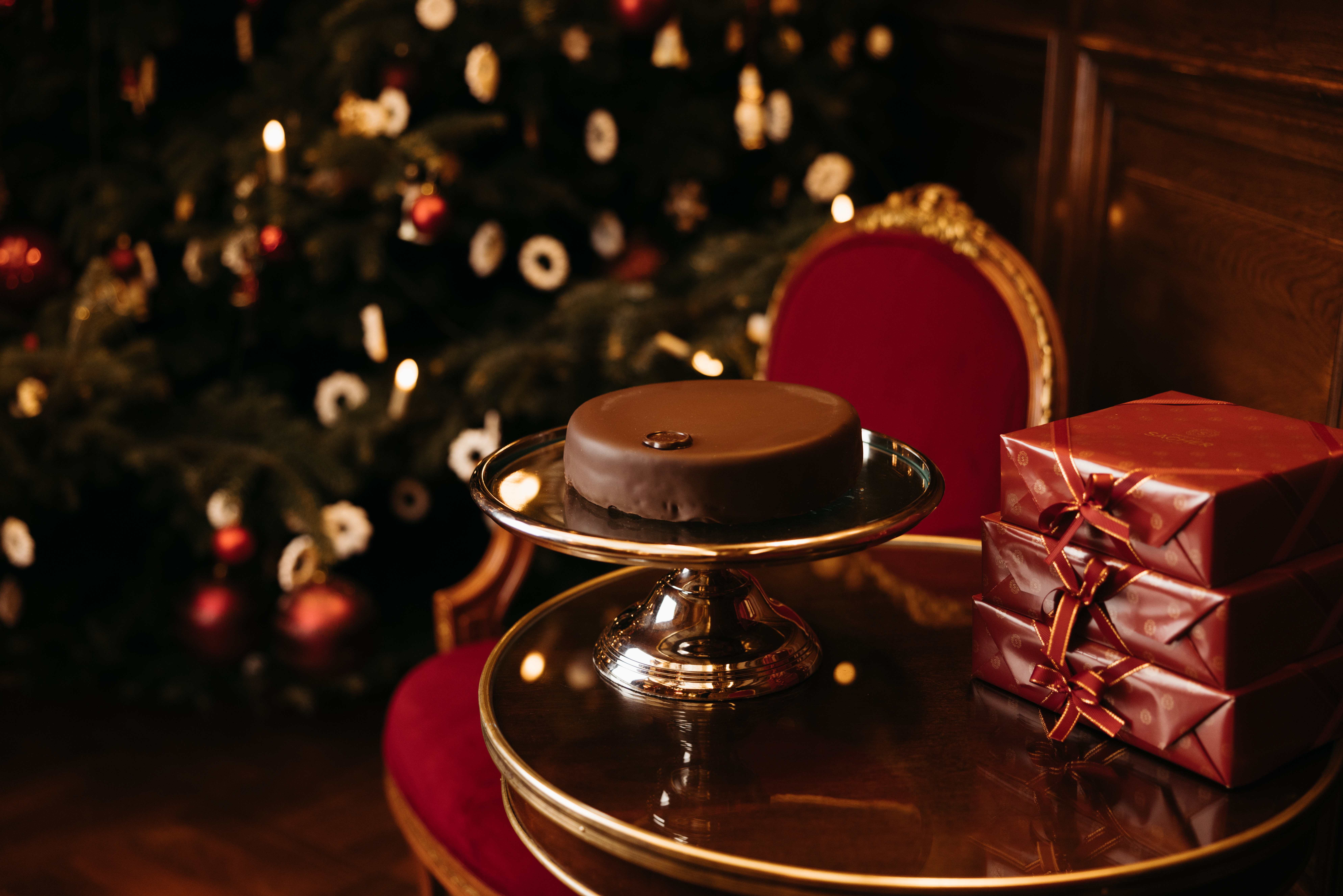 Original Sacher-Torte next to a set of presents and a Christmas tree